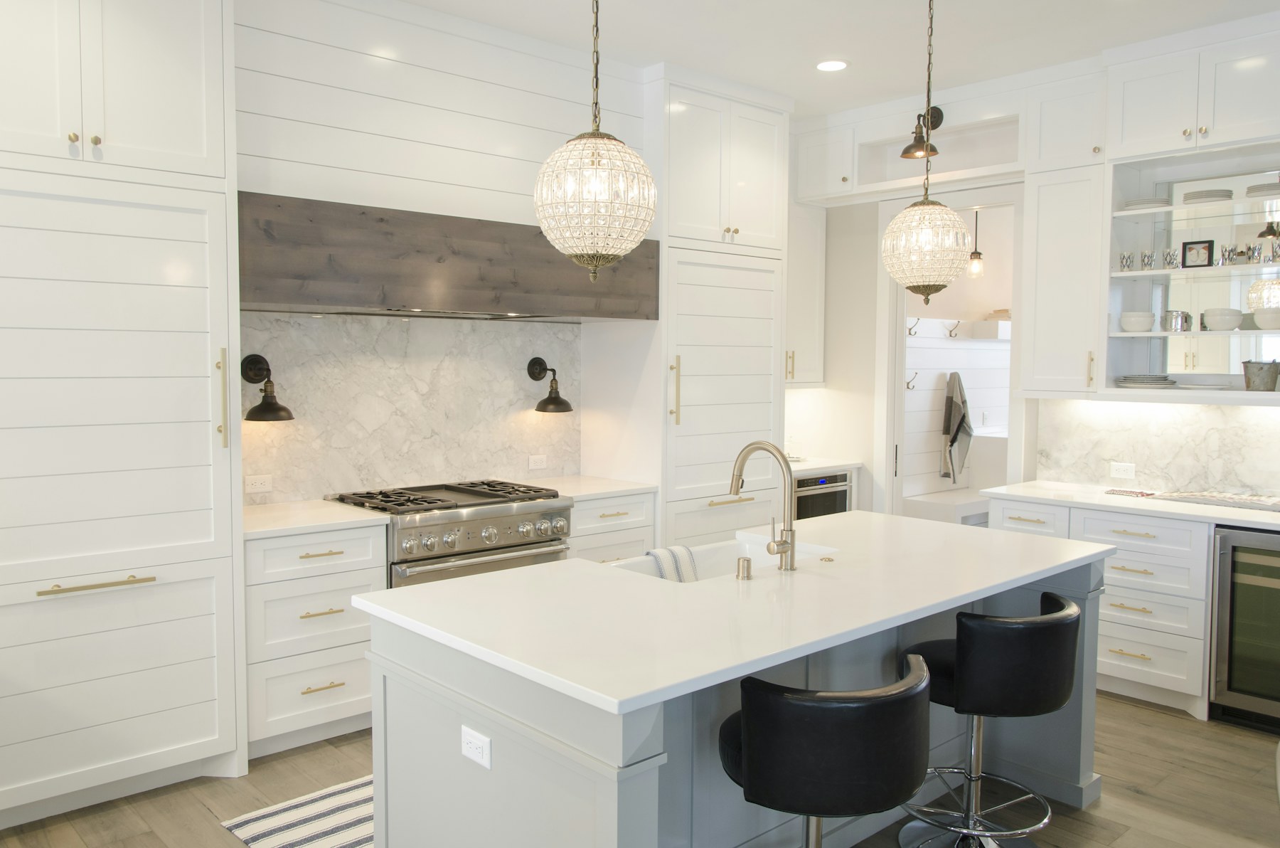 Bright remodeled kitchen with white cabinetry, island seating and pendant lighting